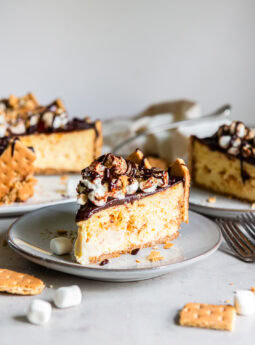 Slice of s'mores cheesecake served on a plate.