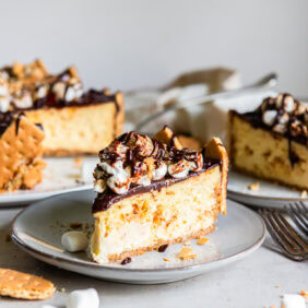 Slice of s'mores cheesecake served on a plate.