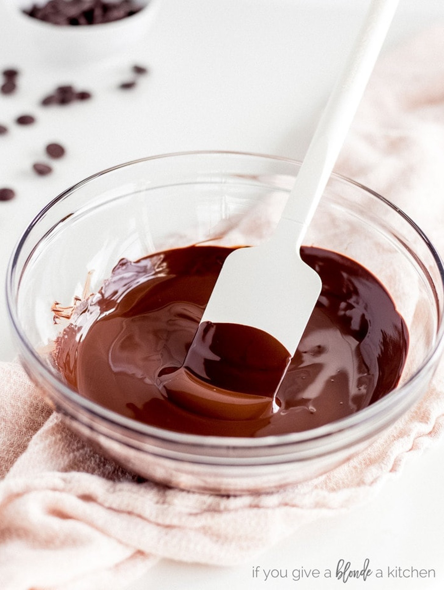 silicone spatula in glass bowl of melted chocolate.