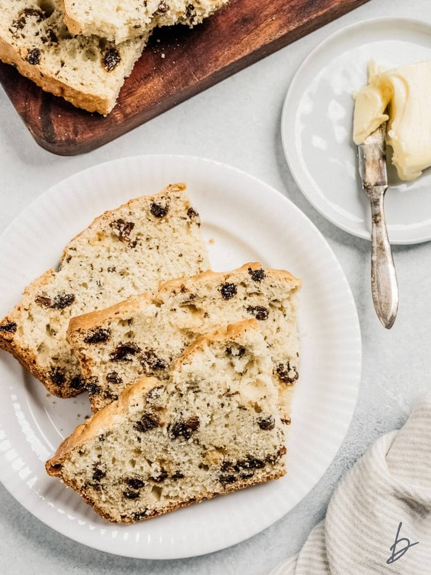 white plate with three slices of irish soda bread with raisins.