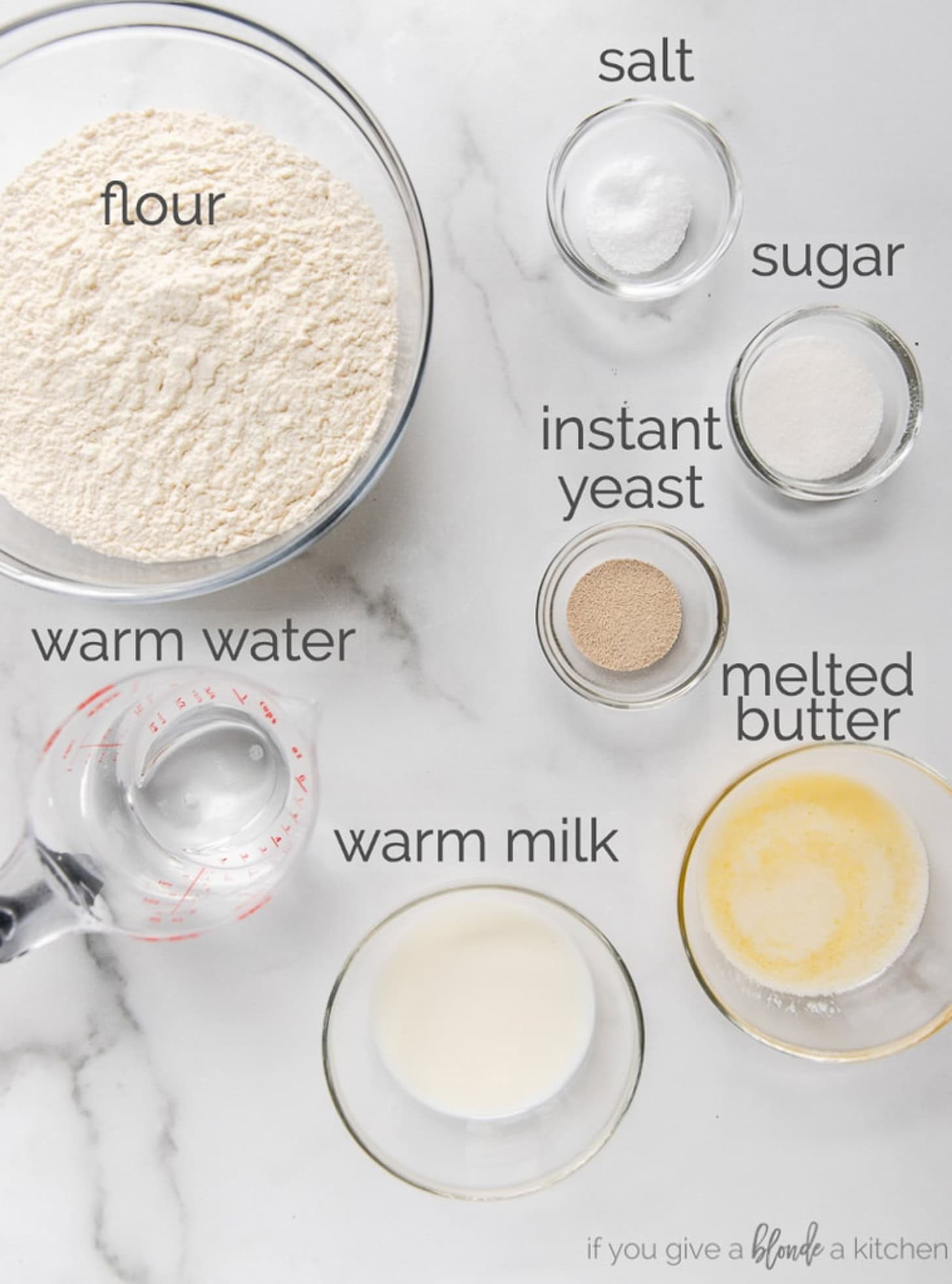 tabletop with bowls of ingredients to make homemade sandwich bread.