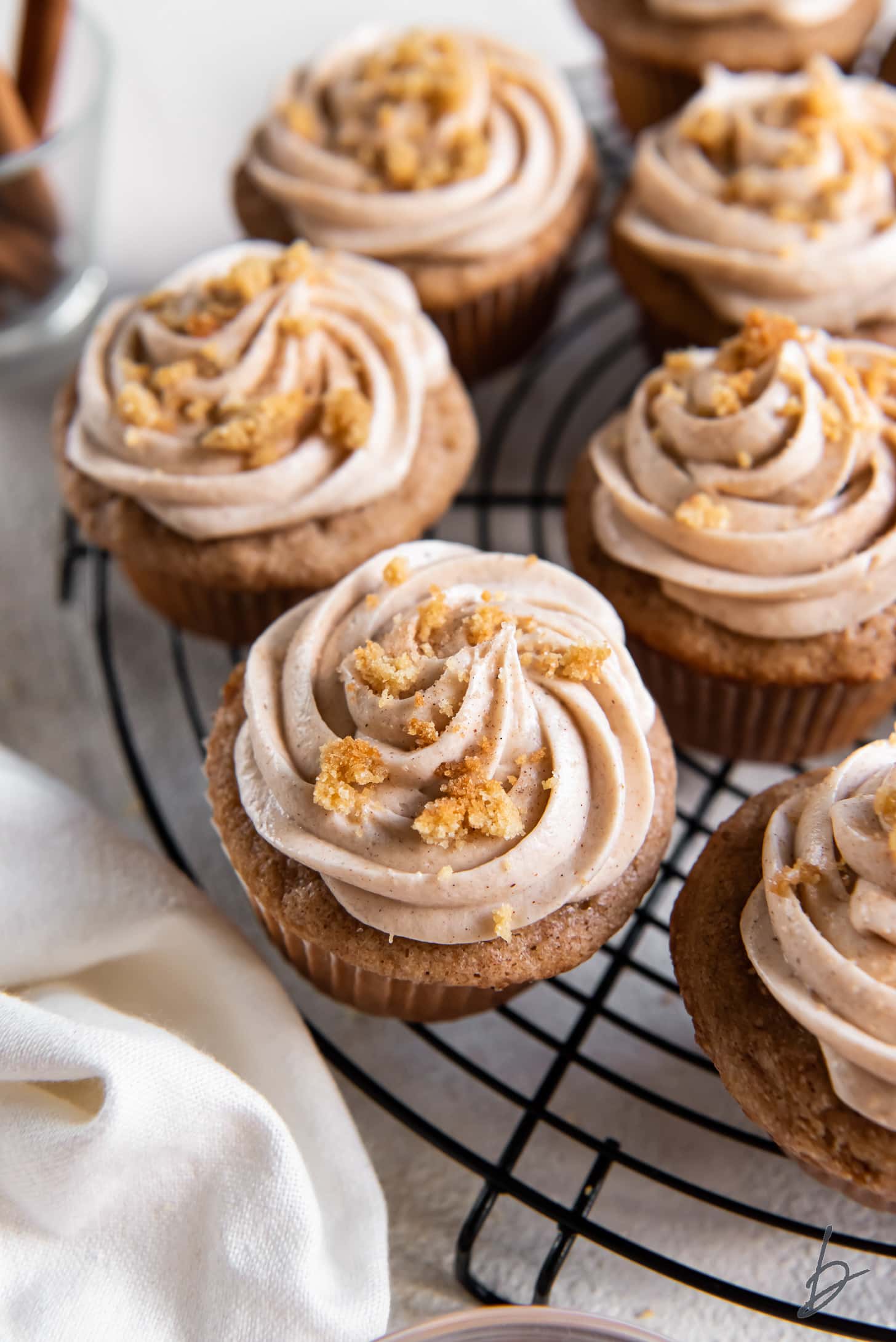 wire rack with frosted snickerdoodle cupcakes garnished with cookie crumbs.