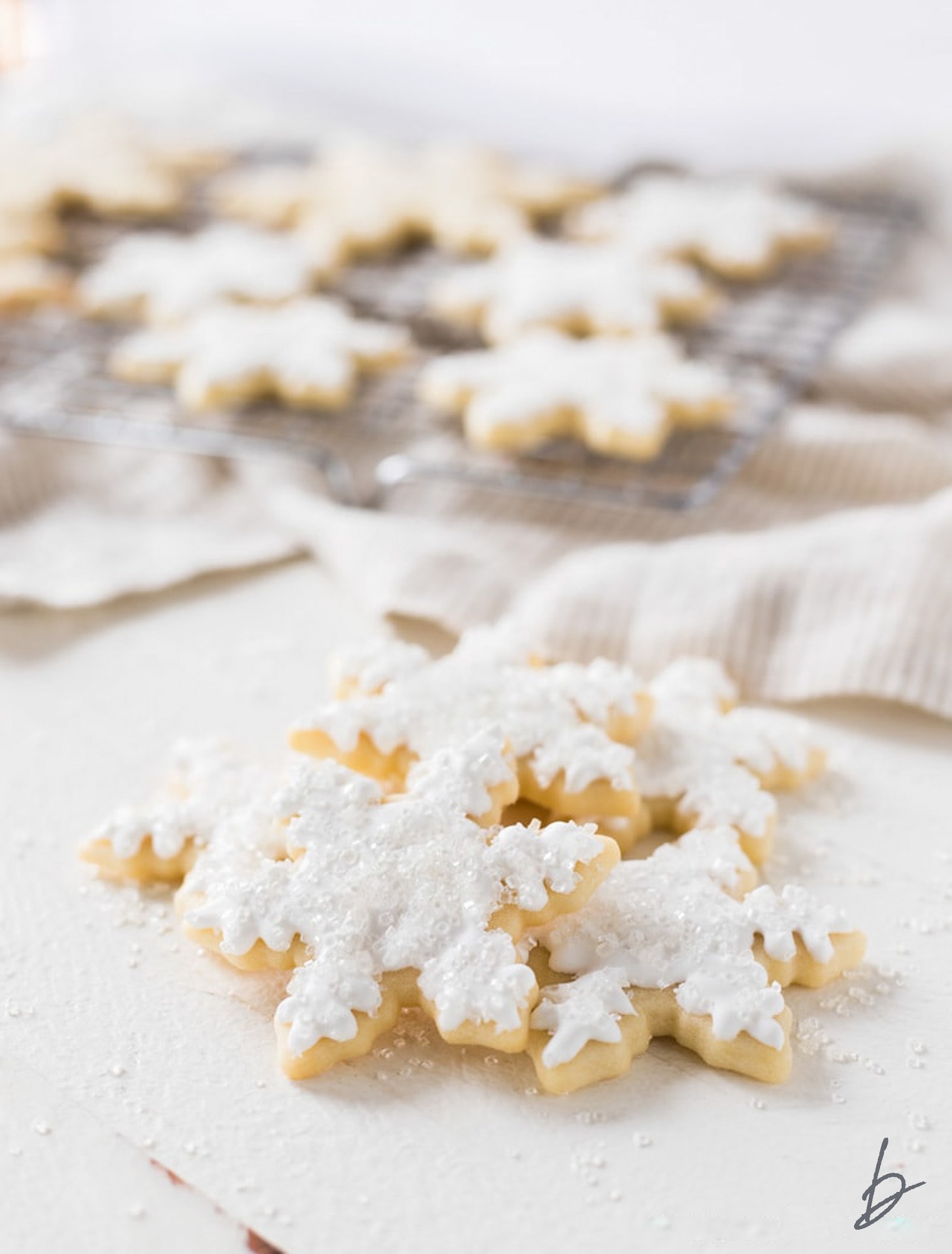 pile of snowflake sugar cookies with royal icing.
