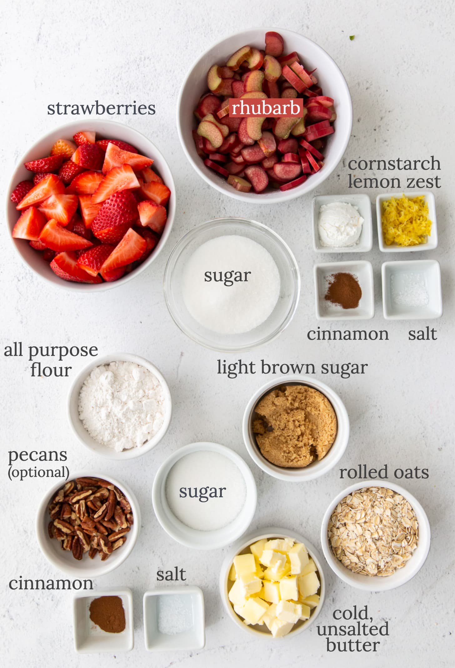 strawberry rhubarb crisp ingredients in bowls labeled with text.