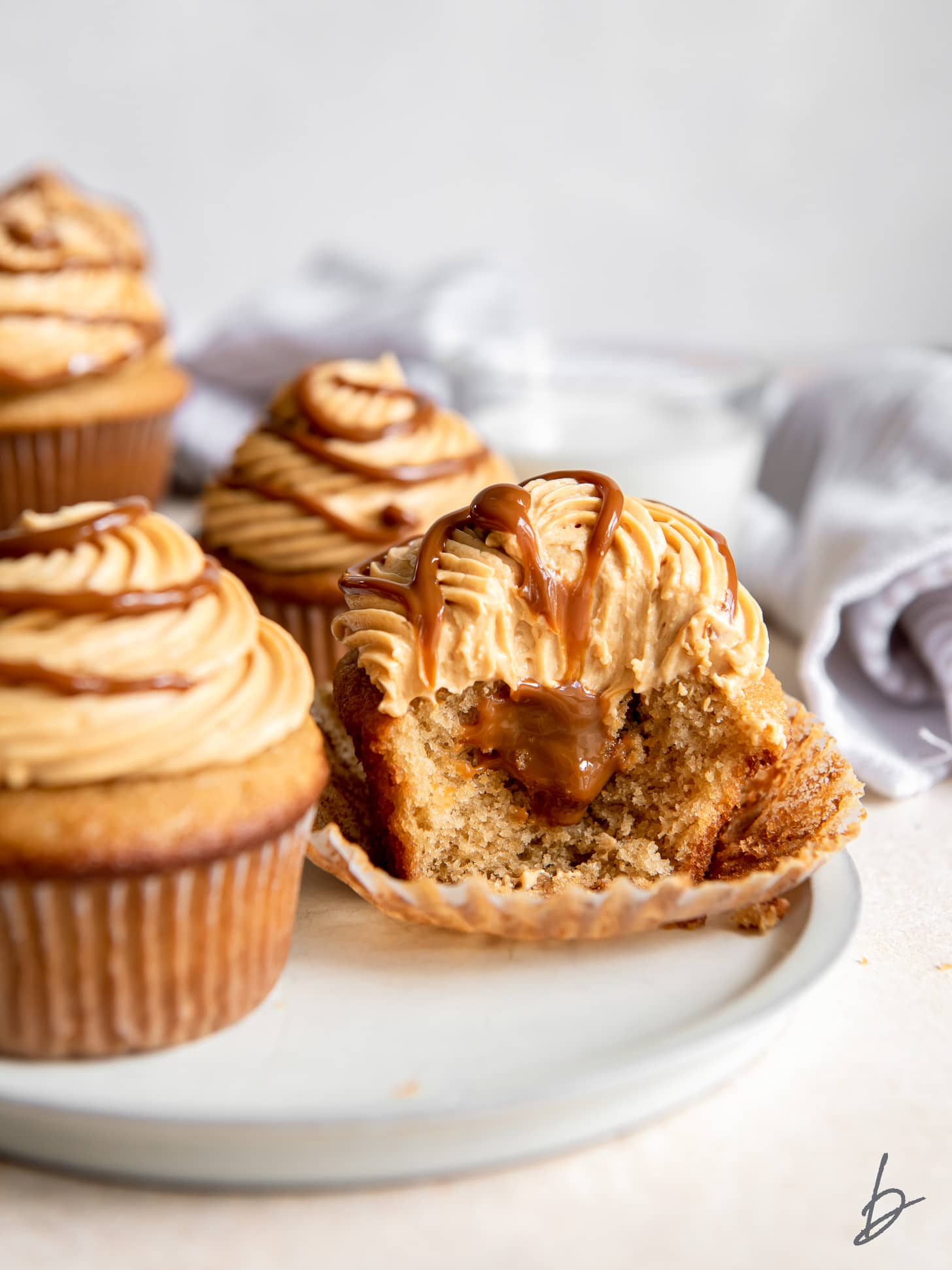 stuffed dulce de leche cupcake with a bite showing filling inside.