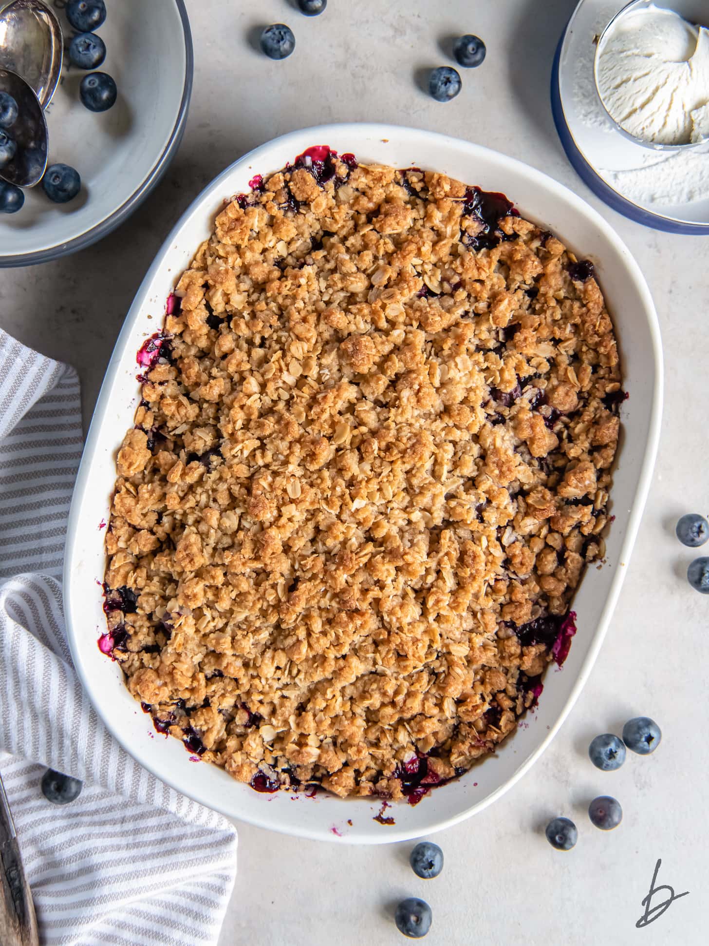 blueberry crisp in a baking dish with oat topping.
