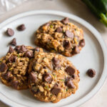 three zucchini chocolate chip cookies on a plate.