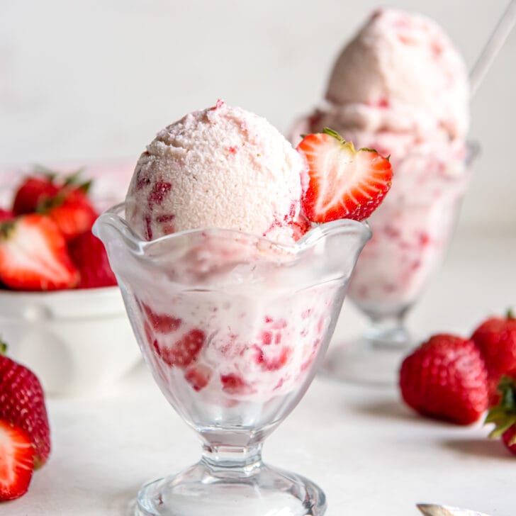homemade strawberry ice cream in a glass sundae dish.