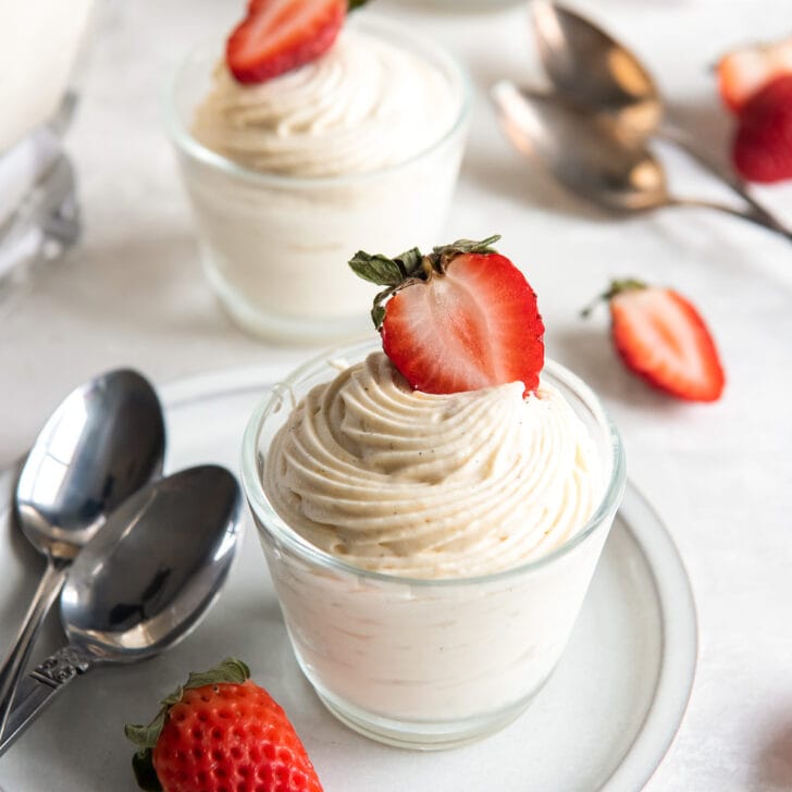 vanilla mousse in glass cup with strawberry garnish.