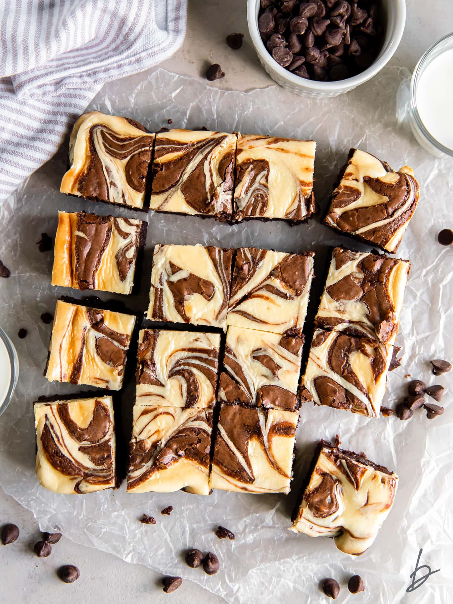 cream cheese swirl brownies cut into squares on parchment paper.