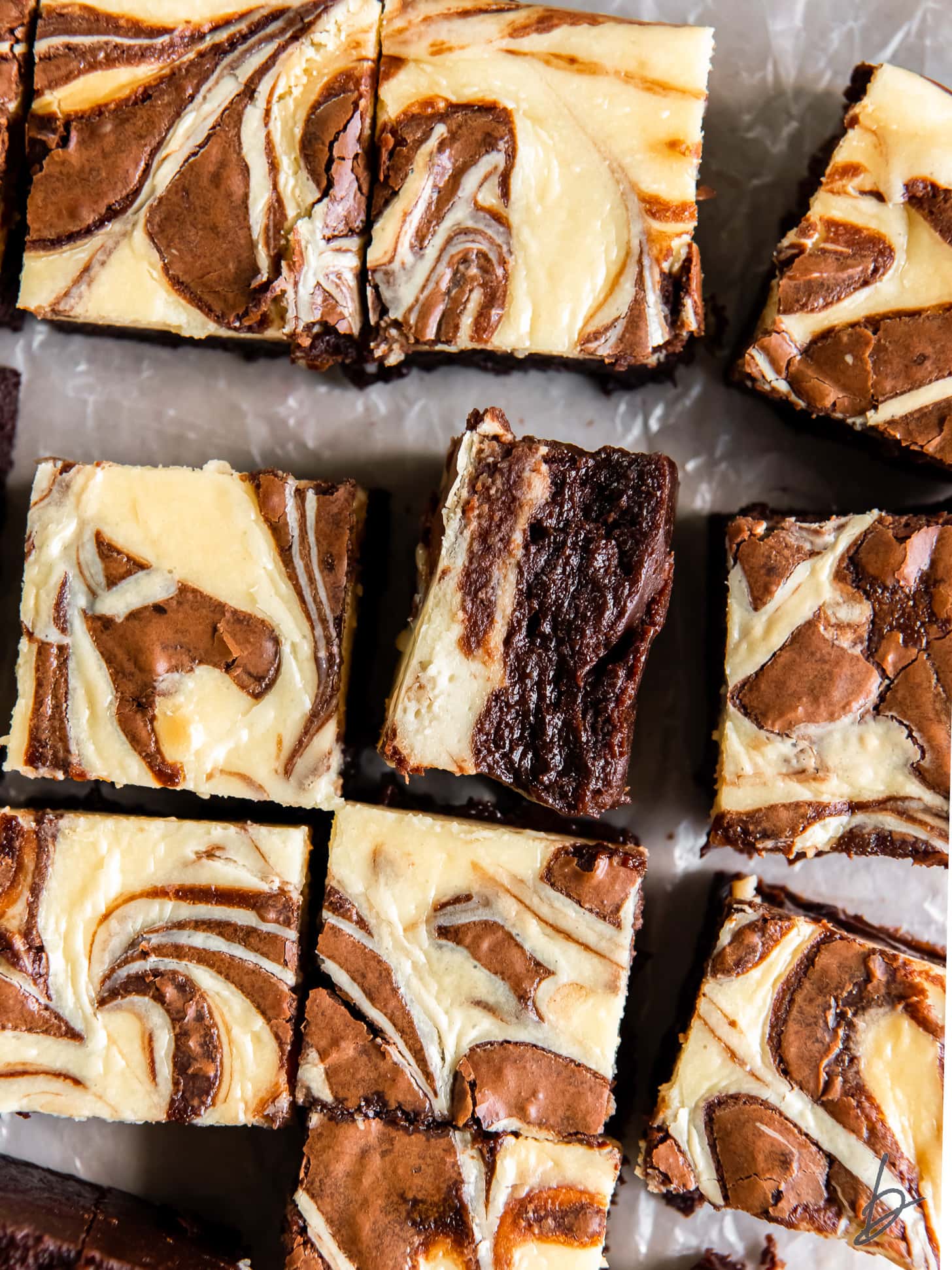 cream cheese swirl brownie on its side next to more brownies.