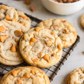 butterscotch chip cookies in a pile on small wire rack.