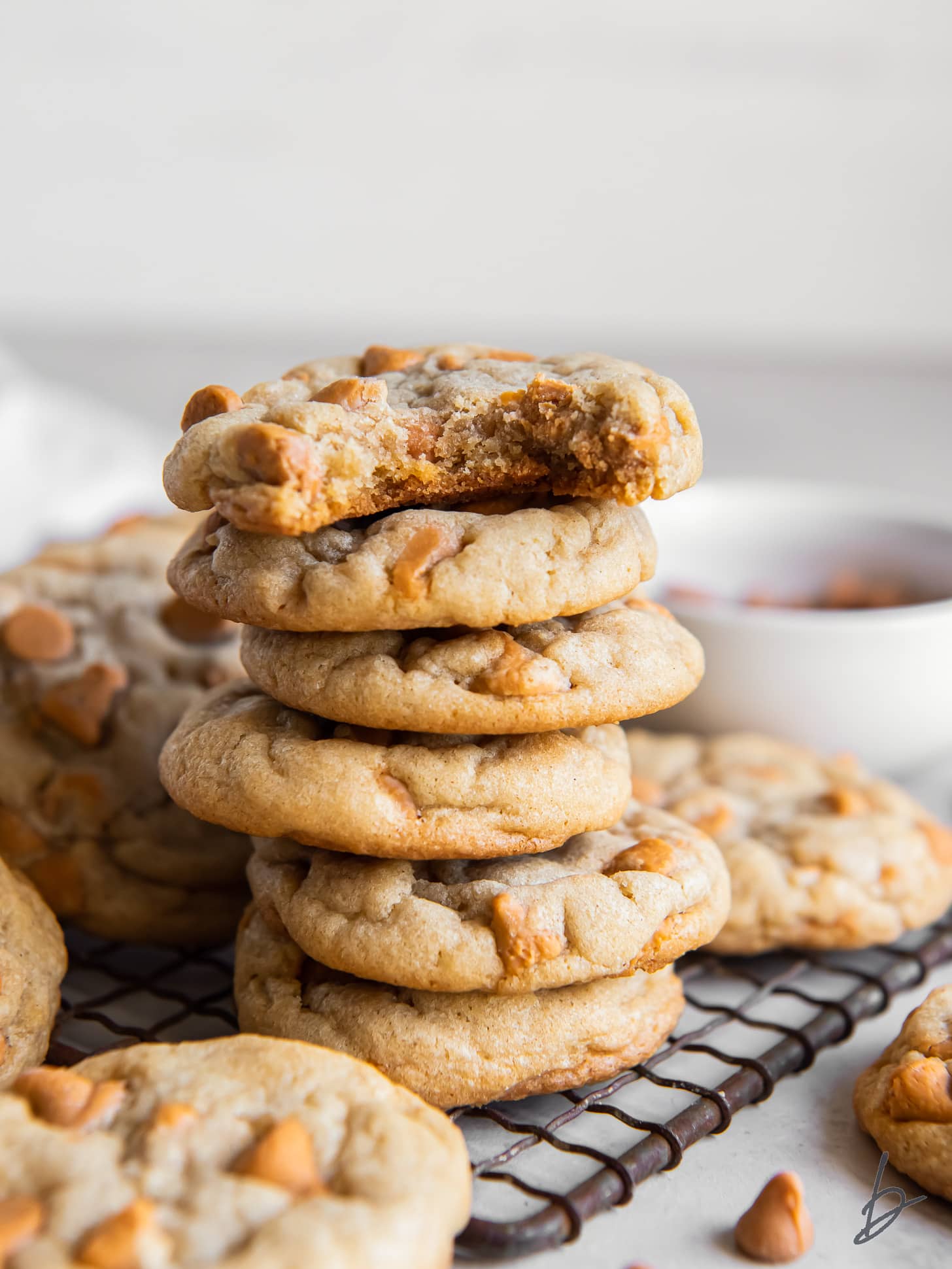 stack of butterscotch chip cookies and the top cookie has a bite.