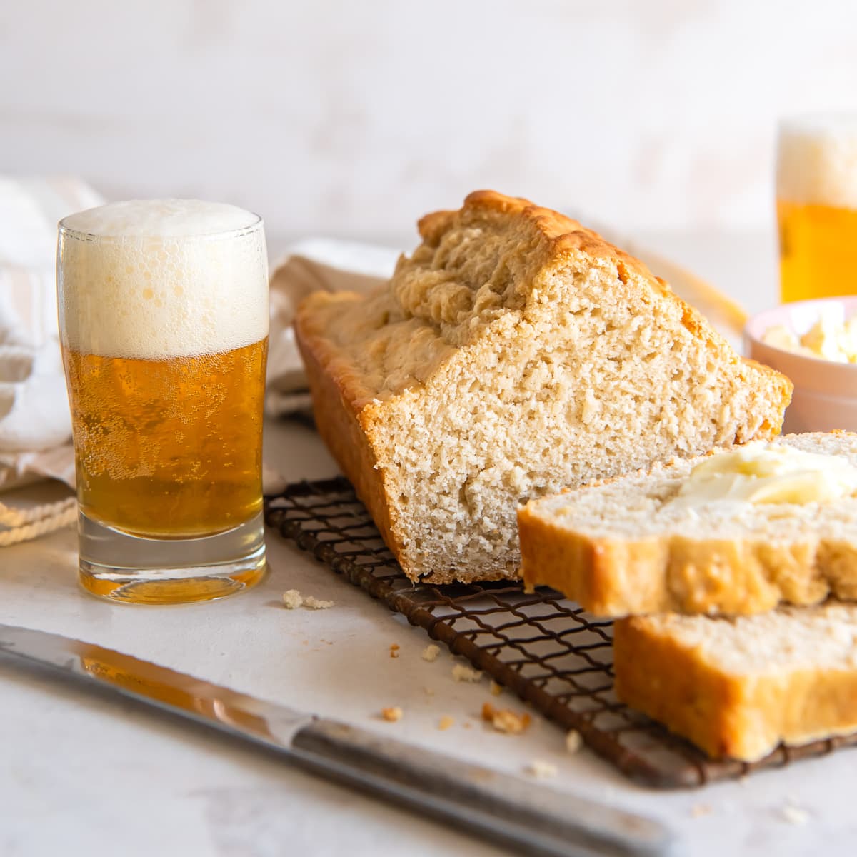 beer bread loaf with a couple slices cut next to a glass of beer.