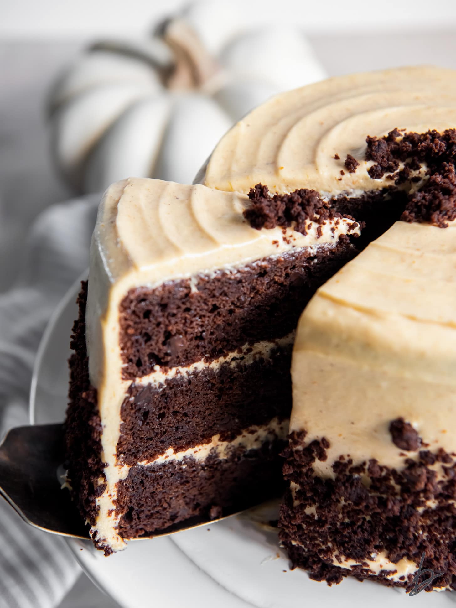 slice of chocolate pumpkin cake being pulled away from the cake showing layers.