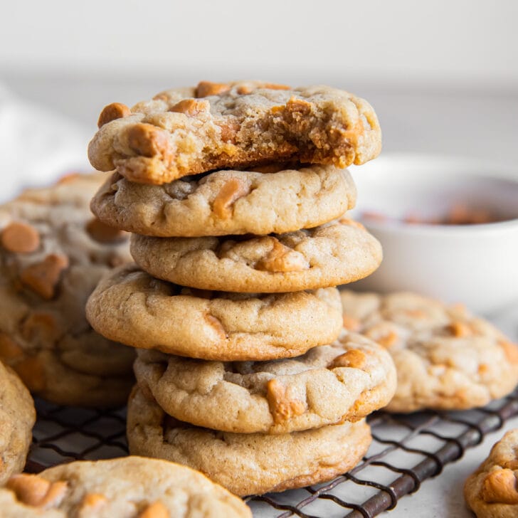 stack of butterscotch chip cookies and top cookie has a bite.
