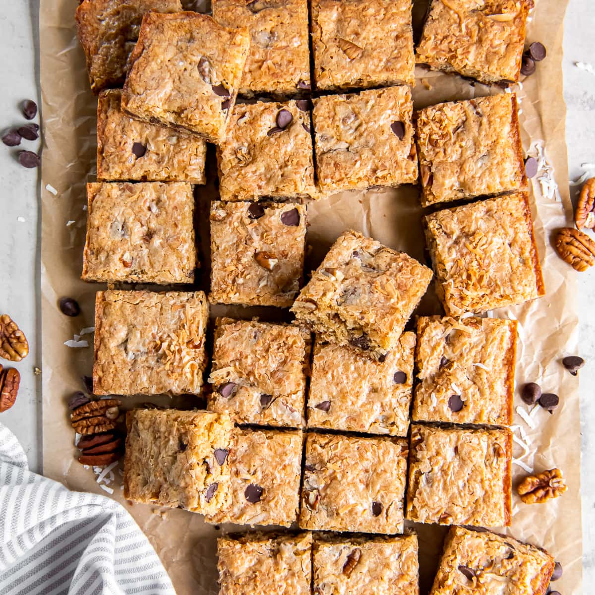 congo bars cut in squares on parchment paper with pecans and chocolate chips.