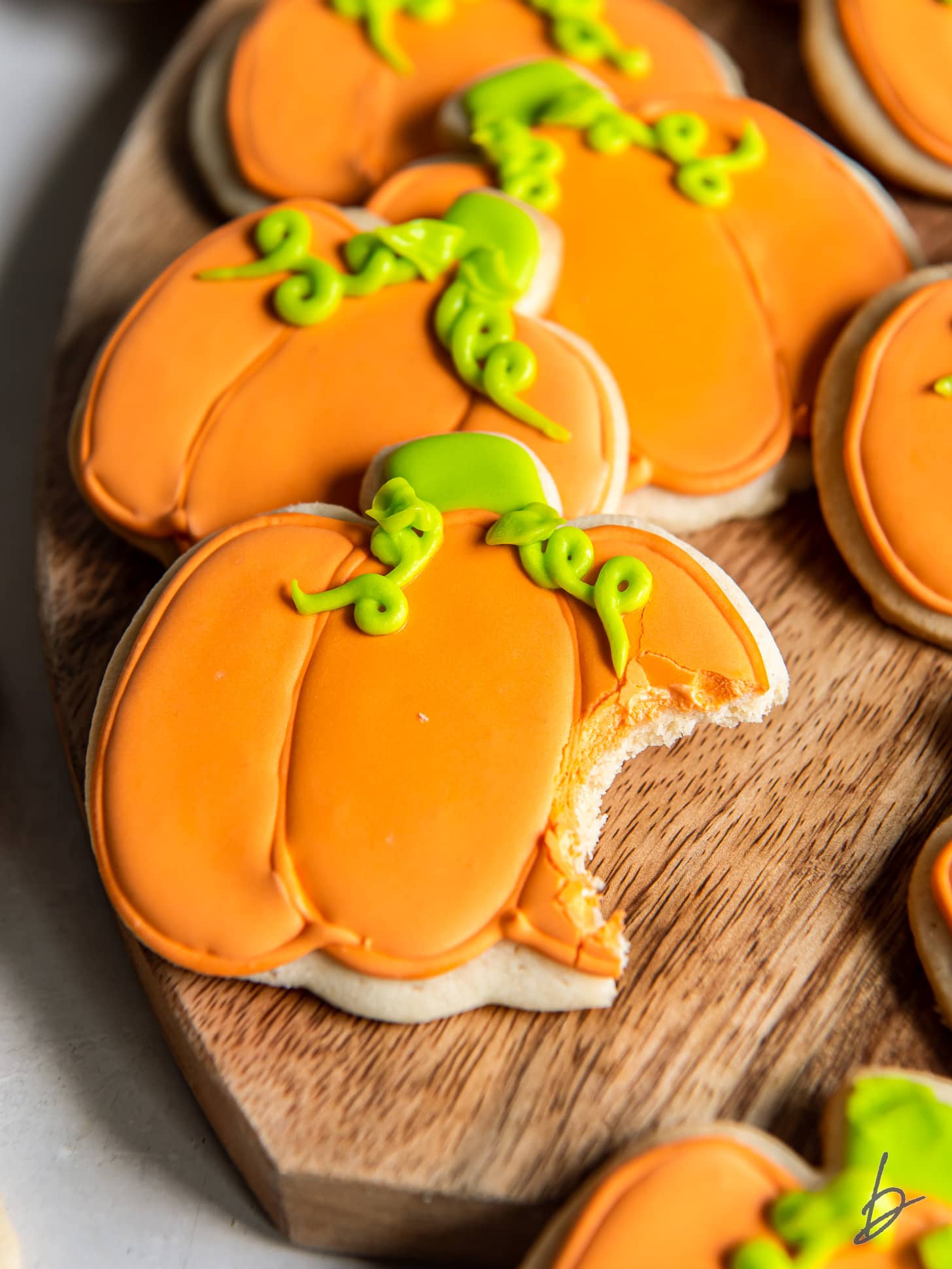 iced pumpkin sugar cookie with a bite.