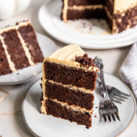 slice of layered chocolate pumpkin cake on a plate with two forks.