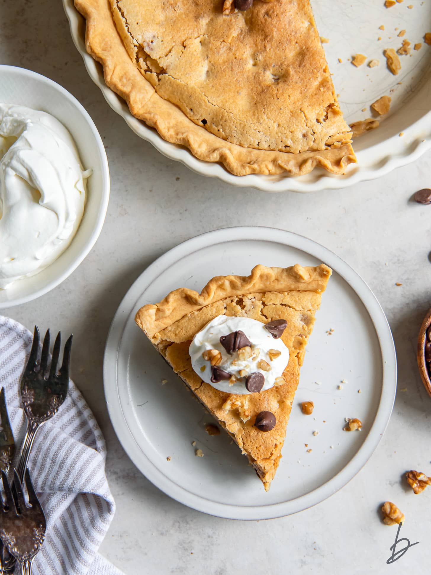 slice of kentucky derby pie on a plate next to the whole pie.