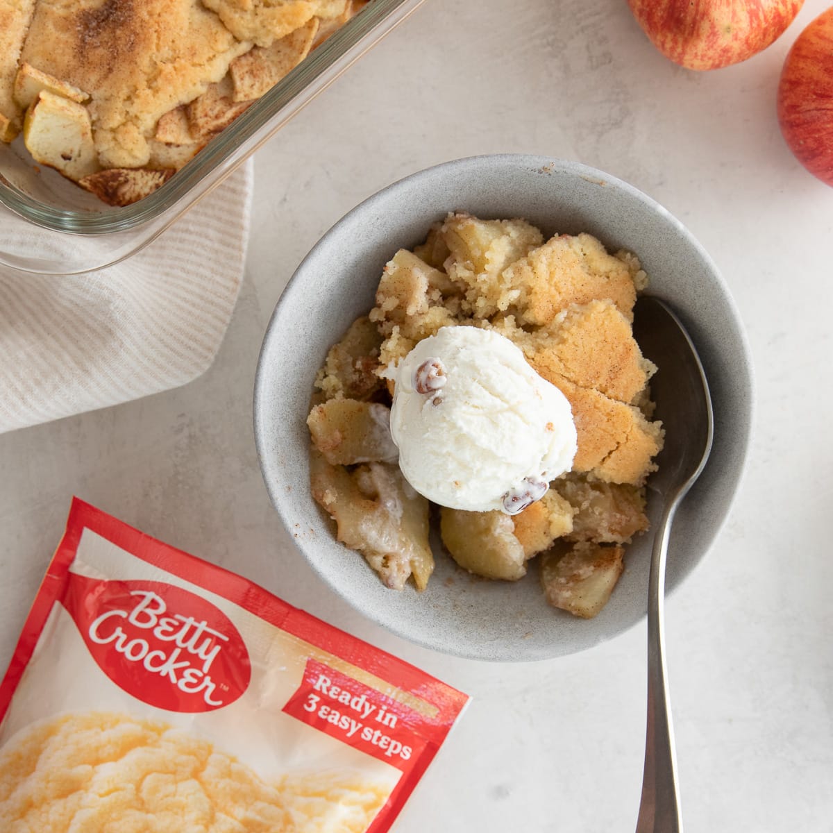 snickerdoodle apple cobbler in a bowl with a scoop of ice cream.