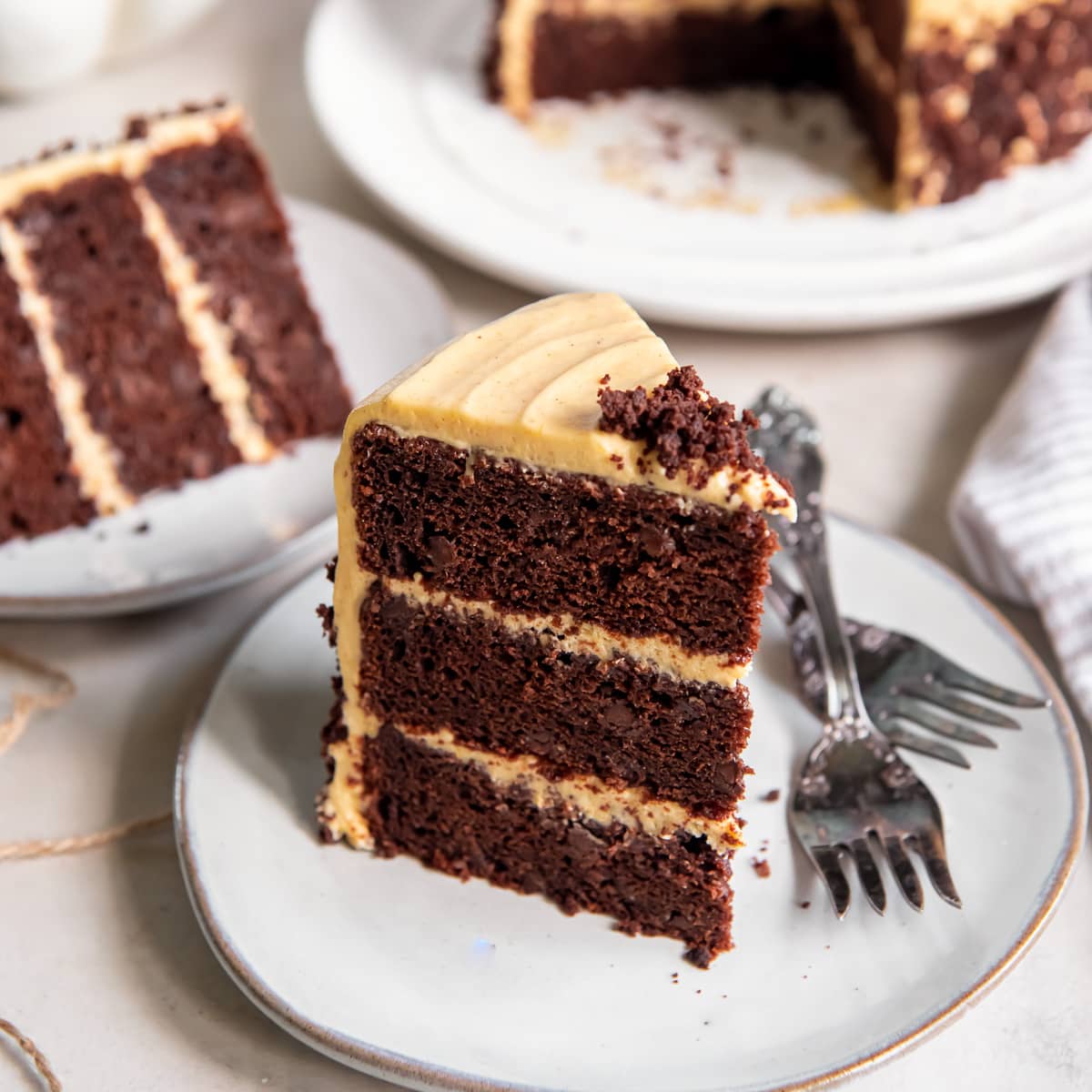 slice of layered chocolate pumpkin cake with pumpkin cream cheese frosting.