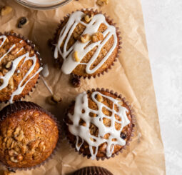 parchment paper with a few maple muffins with glaze and walnut on top.