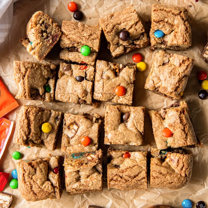 halloween candy cookie bars cut into squares on parchment paper.
