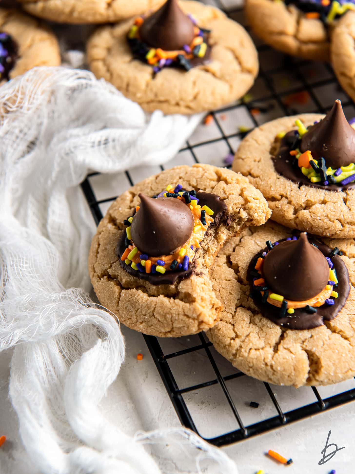 witch hat cookie with a bite leaning on other cookies.