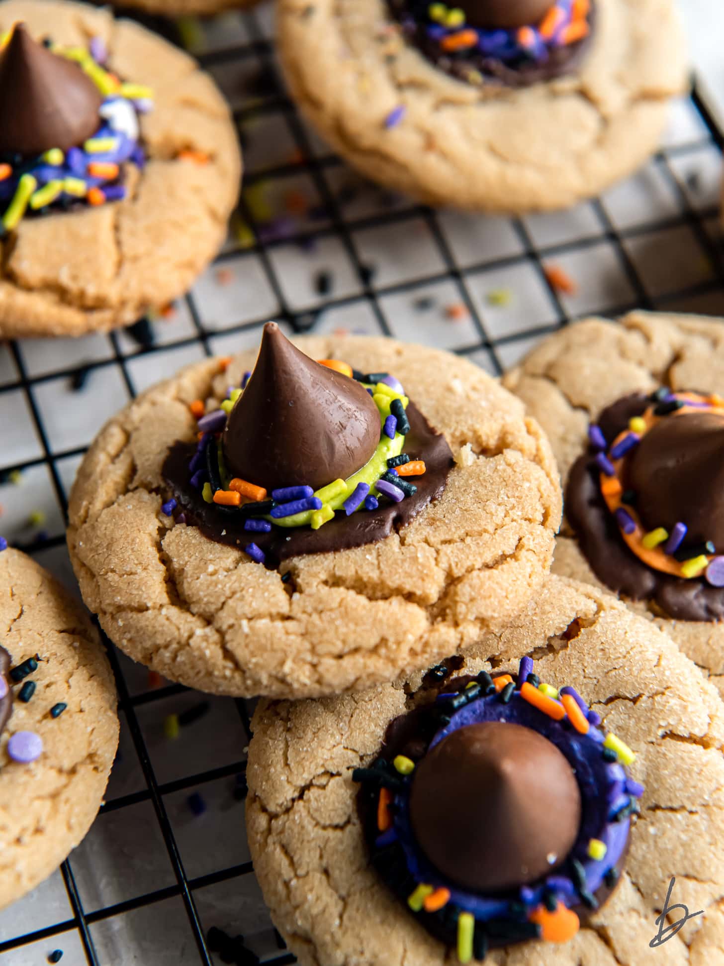 witch hat cookie with chocolate kiss on wire cooling rack with more cookies.