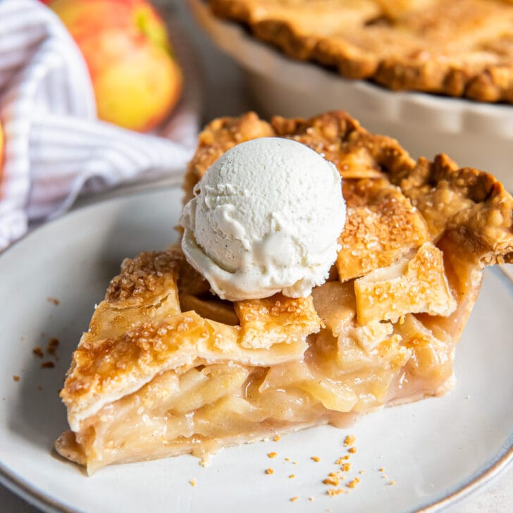 slice of apple pie with lattice crust and scoop of vanilla ice cream.
