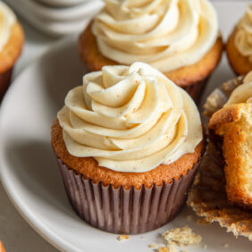 plate with a couple brown butter cupcakes with fluffy brown butter frosting.