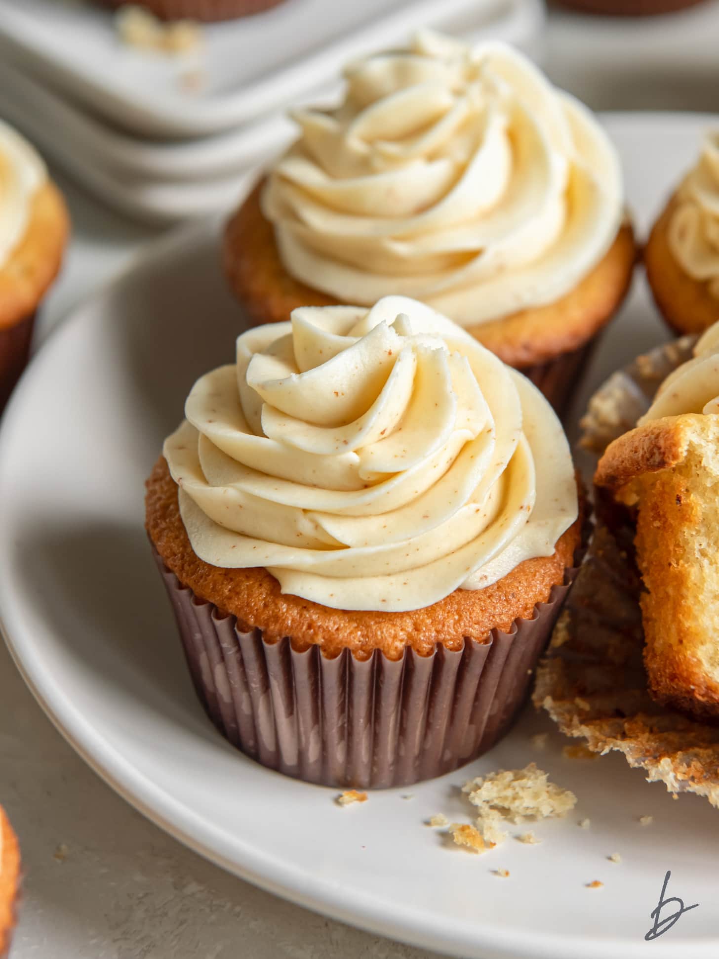 plate with a couple brown butter cupcakes with fluffy brown butter frosting.