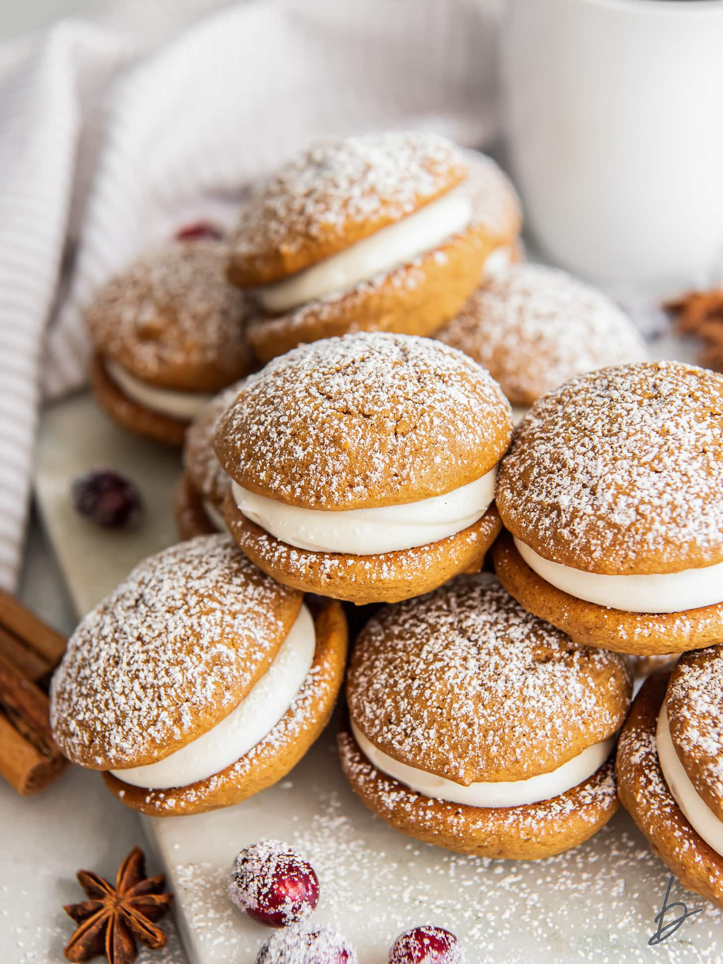 gingerbread whoopie pies in a pile and dusted with confectioners' sugar.