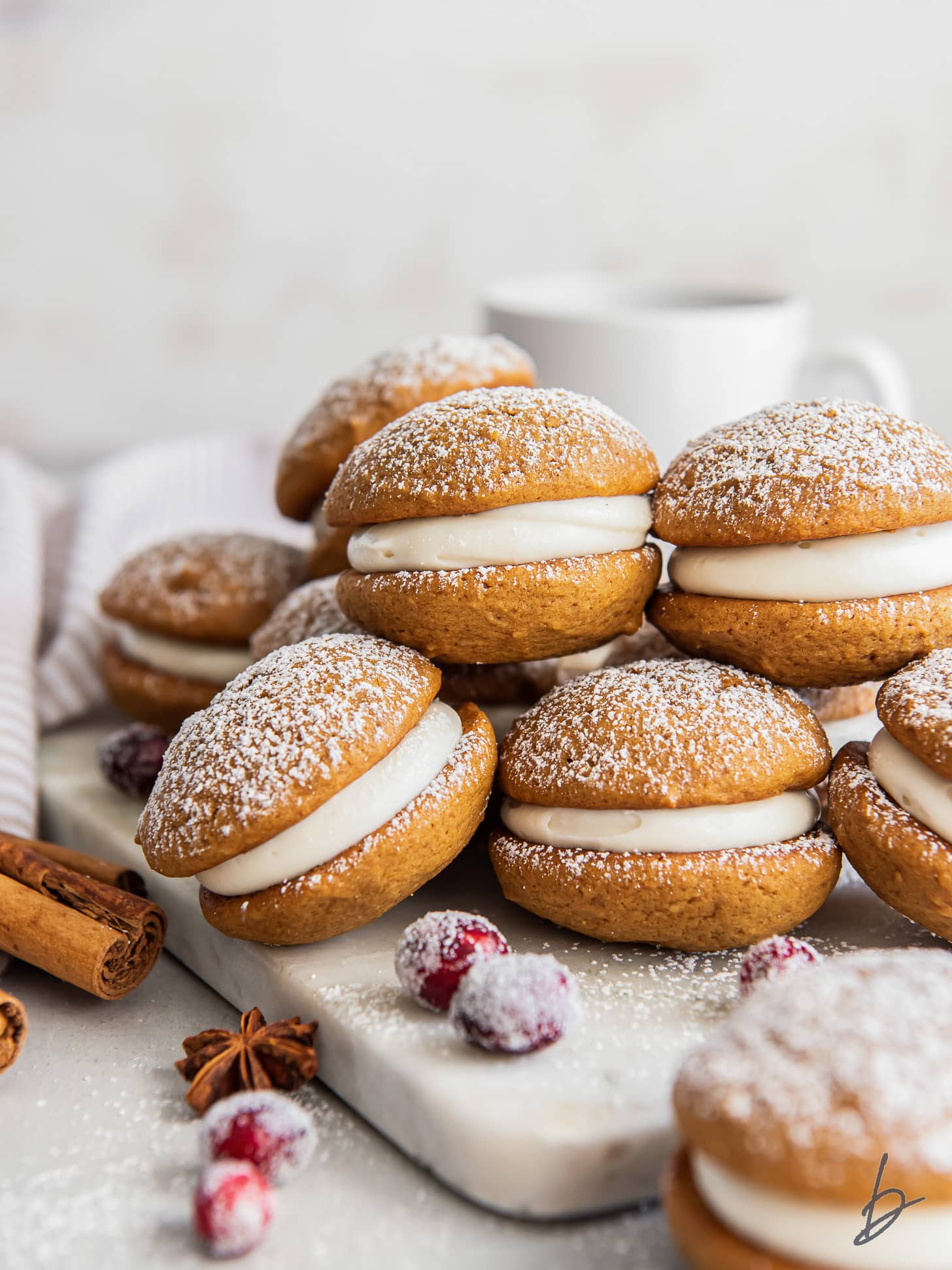 gingerbread whoopie pies filled with cream cheese frosting and stacked on top of each other.