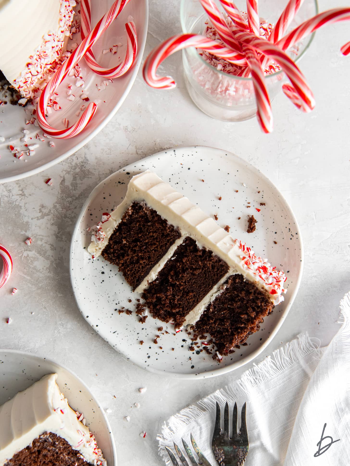 slice of layered chocolate peppermint cake with white chocolate buttercream frosting.