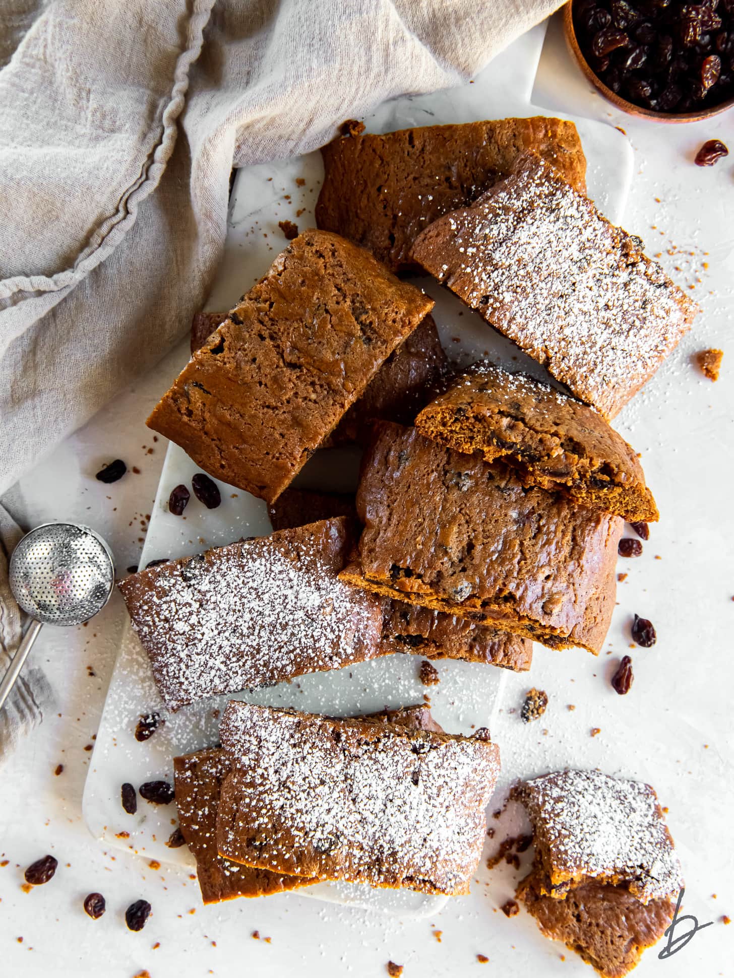 hermit cookies with raisins in a pile and dusted with confectioners' sugar.