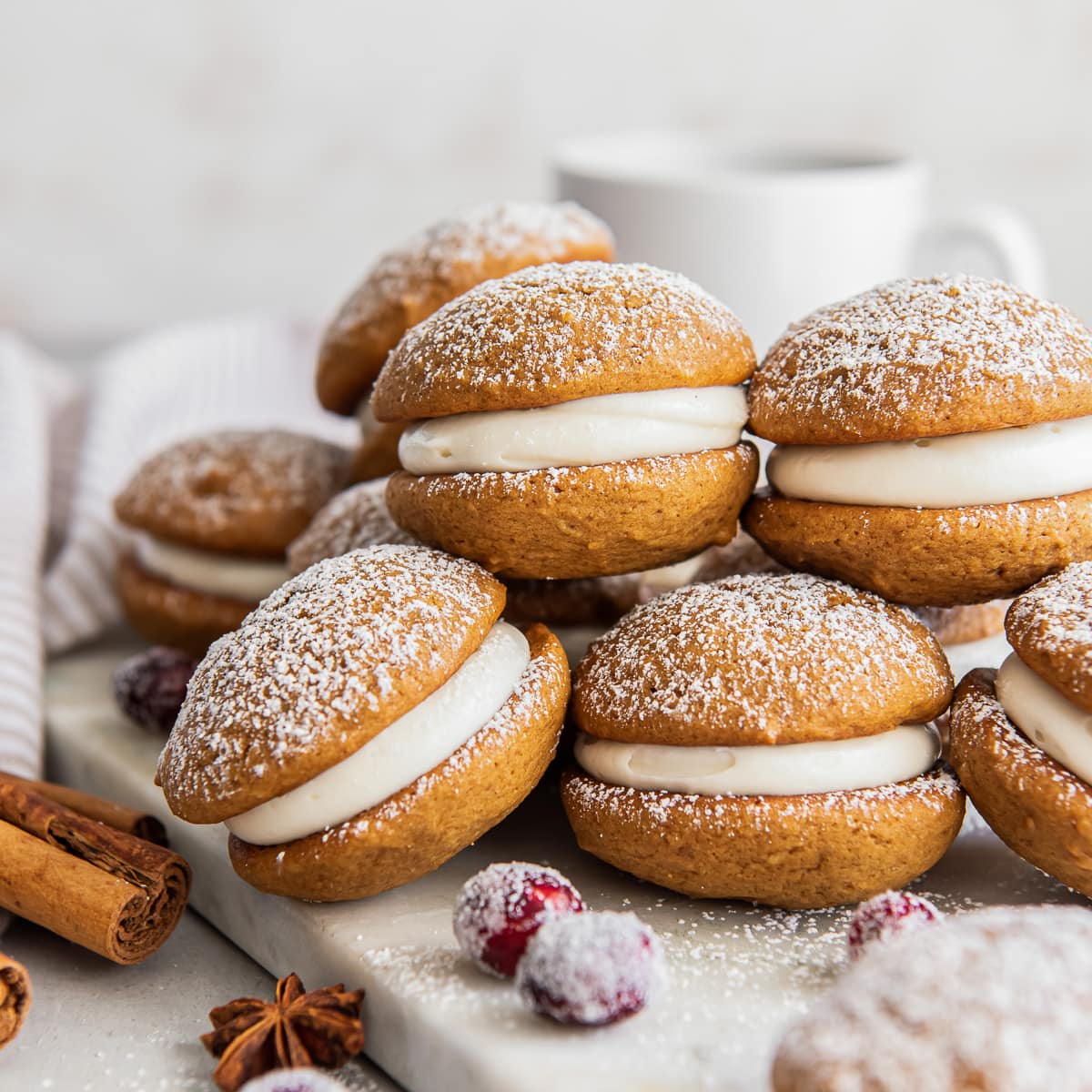 gingerbread whoopie pies in a pile dusted with confectioners' sugar.