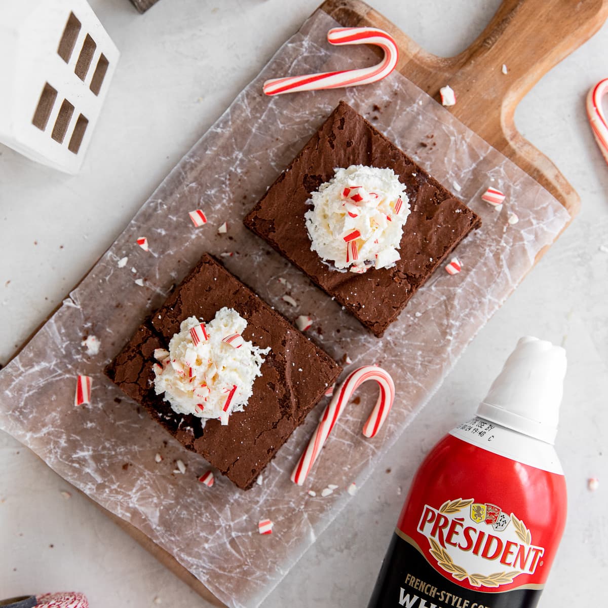two peppermint brownies topped with whipped cream and crushed peppermint.