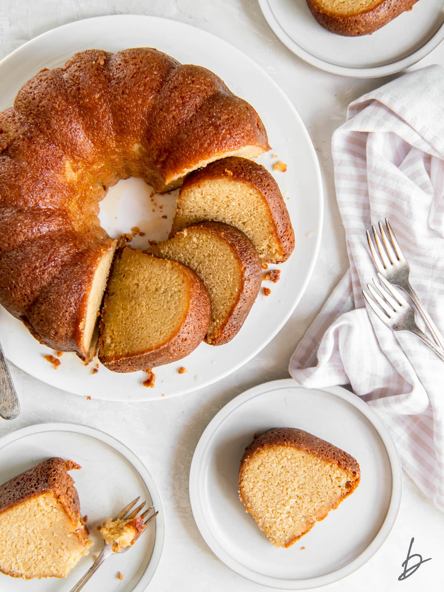 rum soaked cake with slices cut next to a plate with a slice.