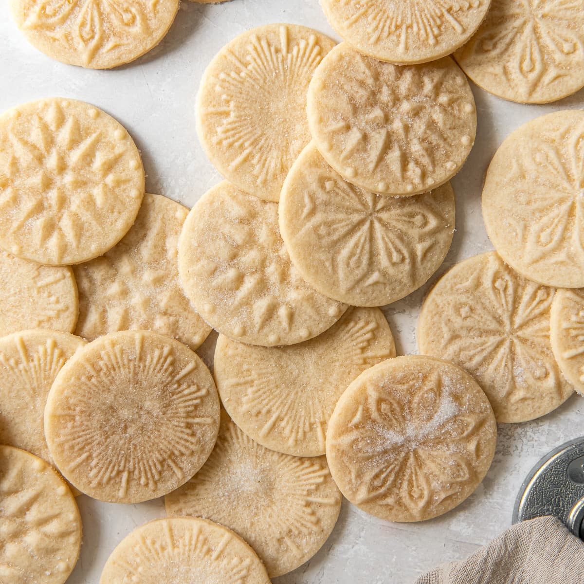 tabletop with stamp shortbread cookies in a pile.