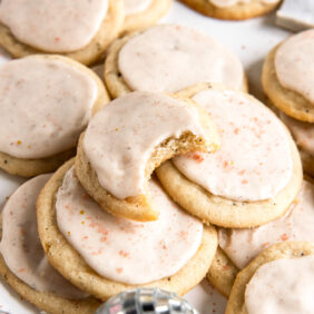 taylor swift chai cookies with icing and sprinkles and one cookie with a bite.