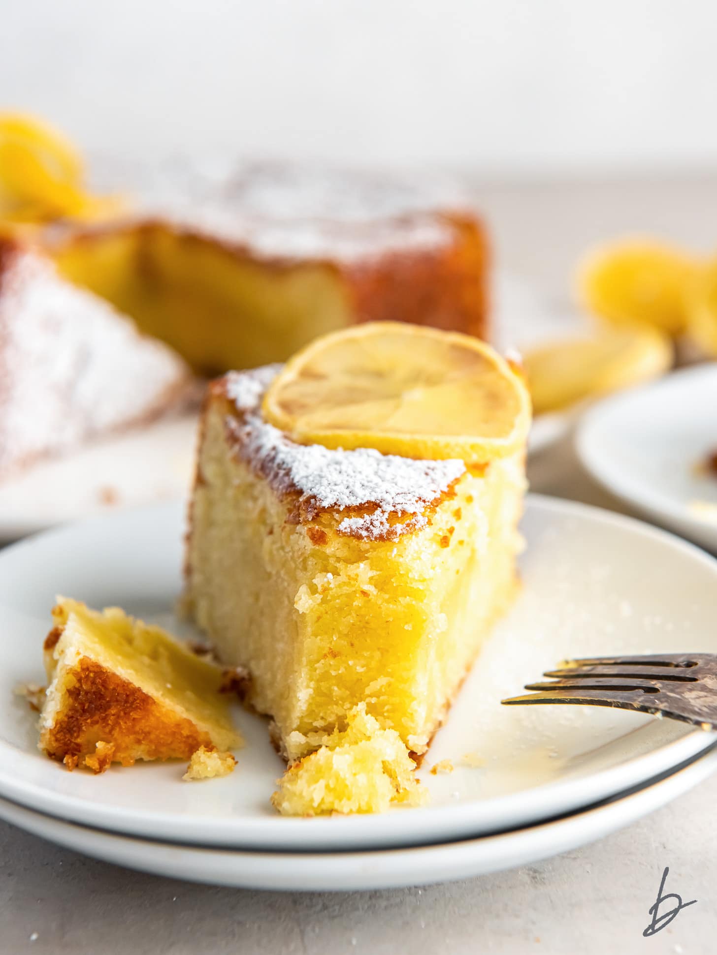 slice of lemon olive oil cake with a bite taken off the end.