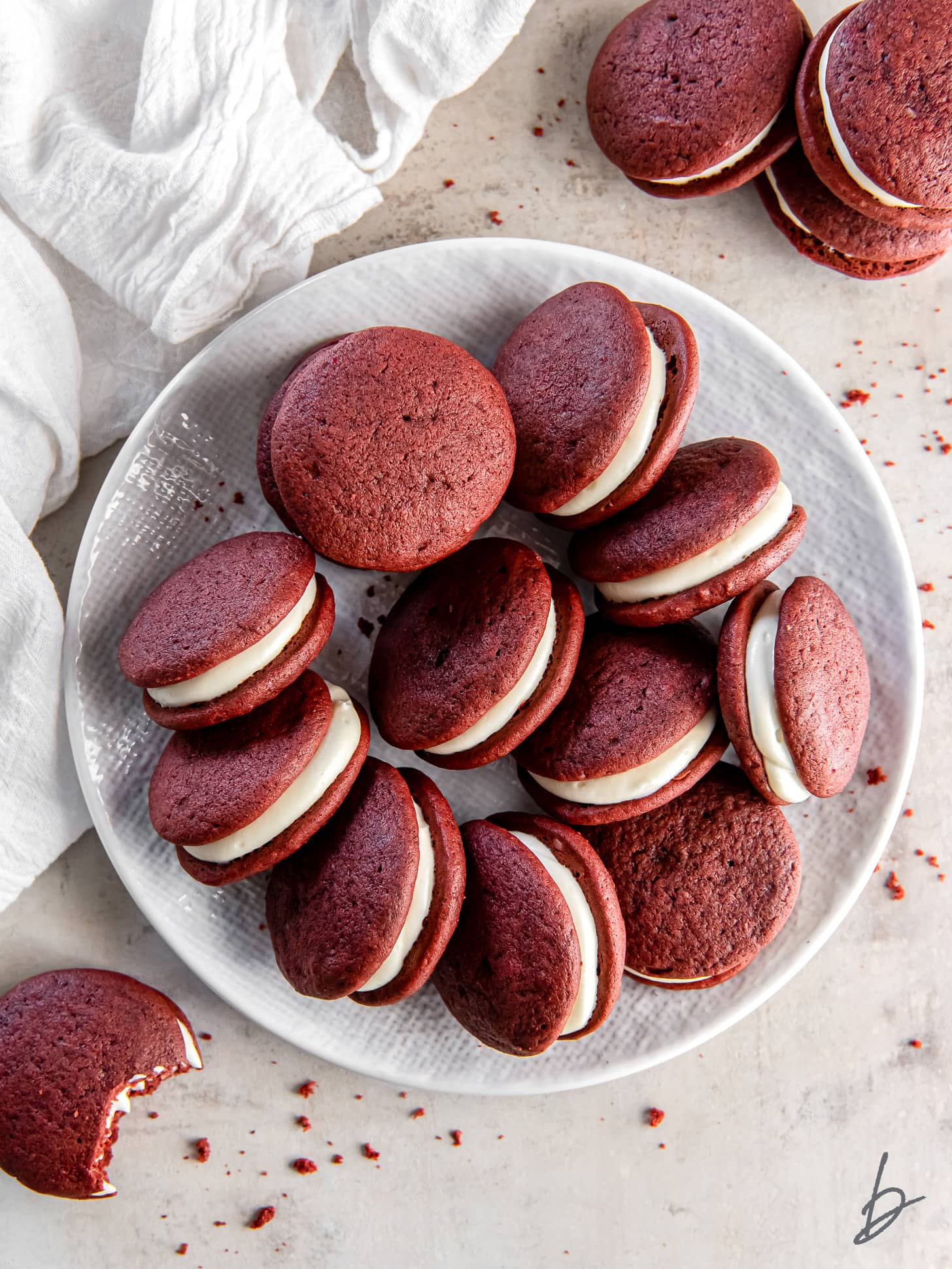 red velvet whoopie pies on a plate on a tabletop.