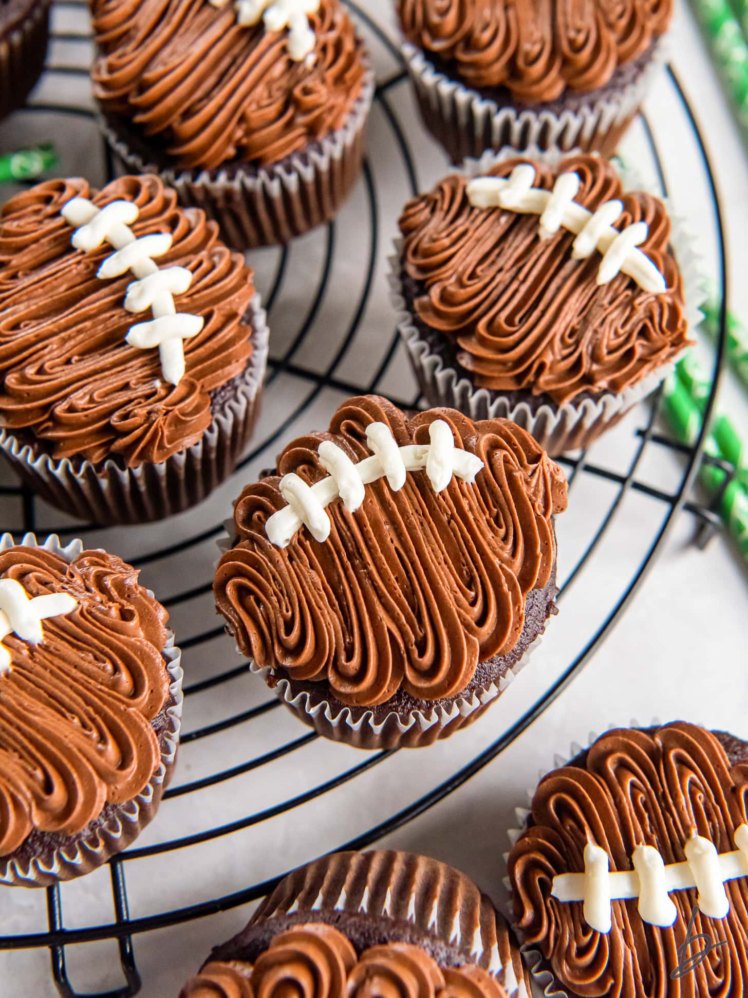 decorated football cupcakes with chocolate frosting.