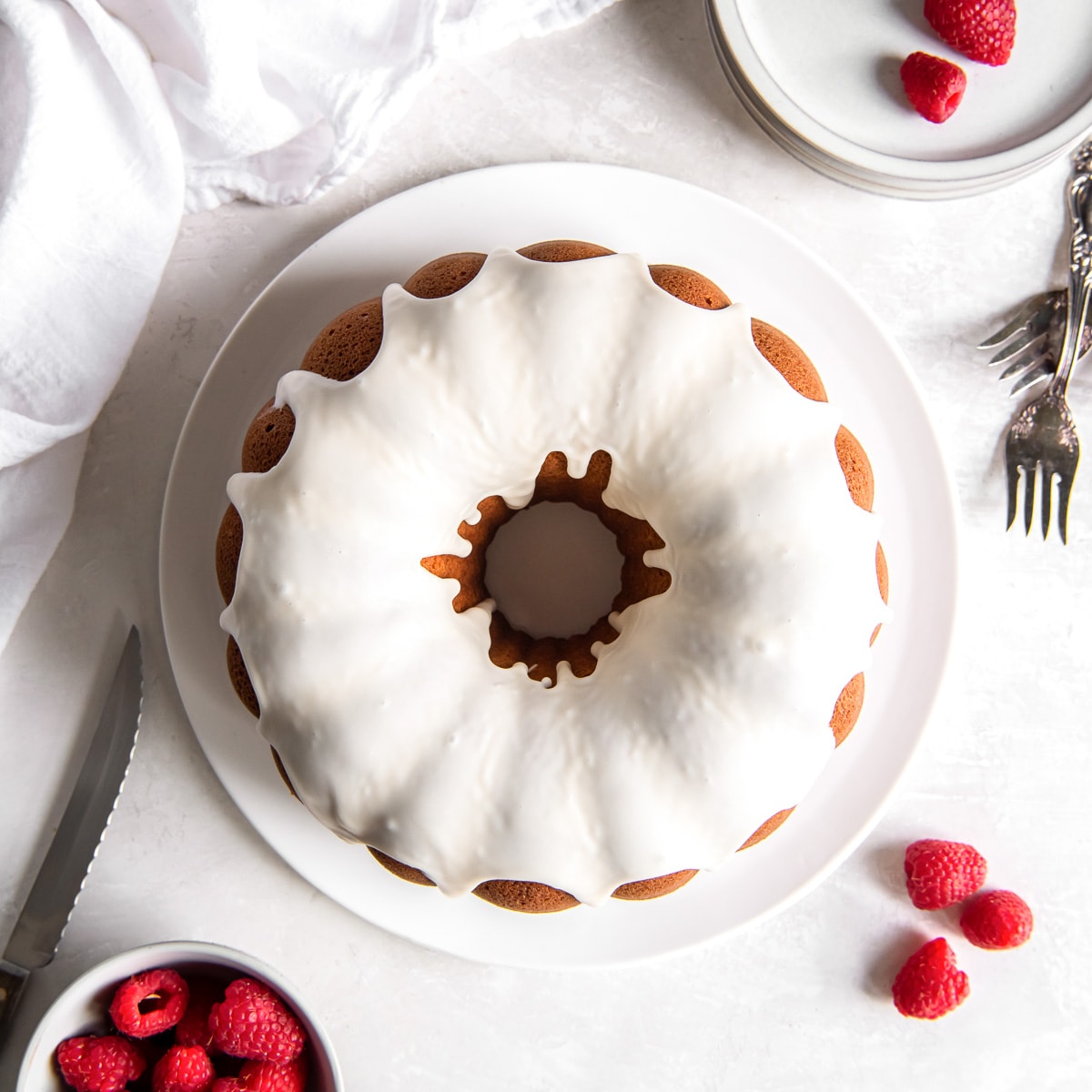 vanilla bundt cake with vanilla glaze on a plate on tabletop.