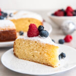 plate with slice of irish apple cake with berries on top.