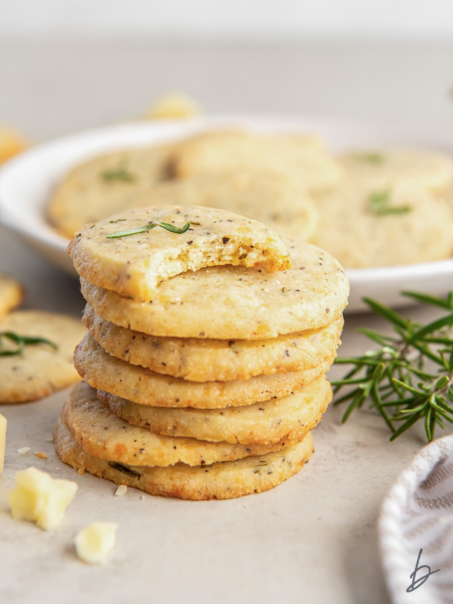 stack of savory shortbread cookies and the top cookie has a bite.