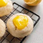 wire rack with lemon curd cookie with yellow curd in the center.