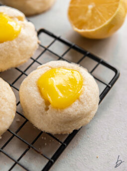 wire rack with lemon curd cookie with yellow curd in the center.